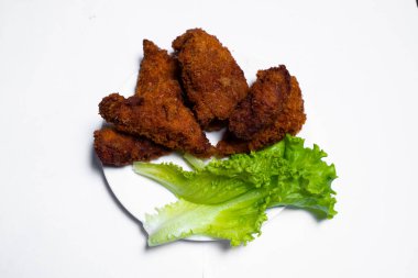 Pişmiş tavuk kanadı, susam tohumlu, otlu ve masada beyaz bir kutuda tatlı soslu.