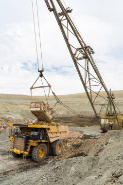 Büyük kazıcı kayaları demir ya da boksit ile doldurur. Bir taş ocağında gökyüzüne karşı dökülür.