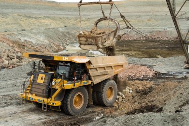 Büyük kazıcı kayaları demir ya da boksit ile doldurur. Bir taş ocağında gökyüzüne karşı dökülür.