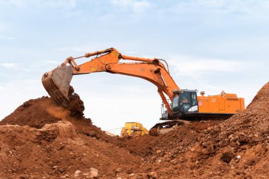 Büyük kazıcı kayaları demir ya da boksit ile doldurur. Bir taş ocağında gökyüzüne karşı dökülür.