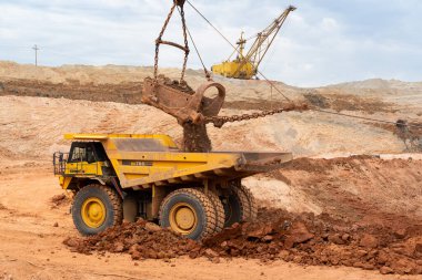 Büyük kazıcı kayaları demir ya da boksit ile doldurur. Bir taş ocağında gökyüzüne karşı dökülür.