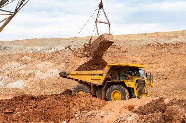 Büyük kazıcı kayaları demir ya da boksit ile doldurur. Bir taş ocağında gökyüzüne karşı dökülür.