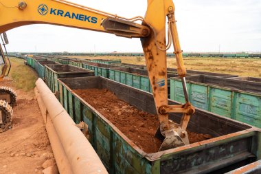 Büyük kazıcı kayaları demir ya da boksit ile doldurur. Bir taş ocağında gökyüzüne karşı dökülür.