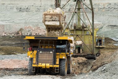 Büyük kazıcı kayaları demir ya da boksit ile doldurur. Bir taş ocağında gökyüzüne karşı dökülür.