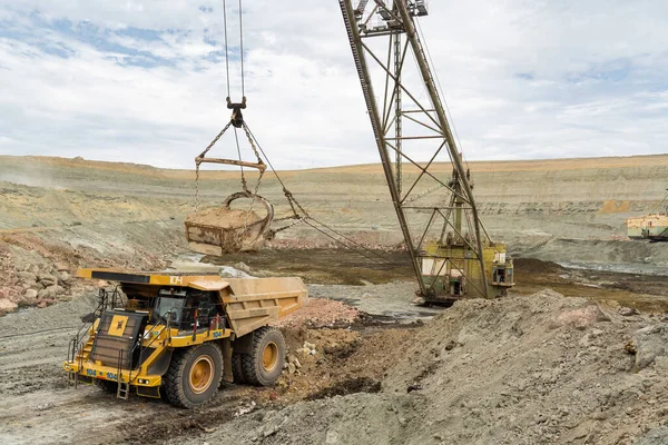 大型挖掘机将岩石装入采石场的铁质或铝土矿倾卸卡车 与天空抗衡 — 图库照片