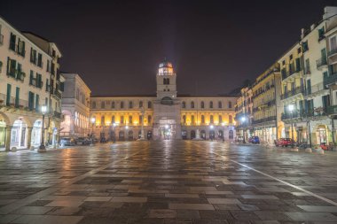 Gece arkaplanda Piazza dei Signori Square ve Torre del Orologio (astronomik saat kulesi)..