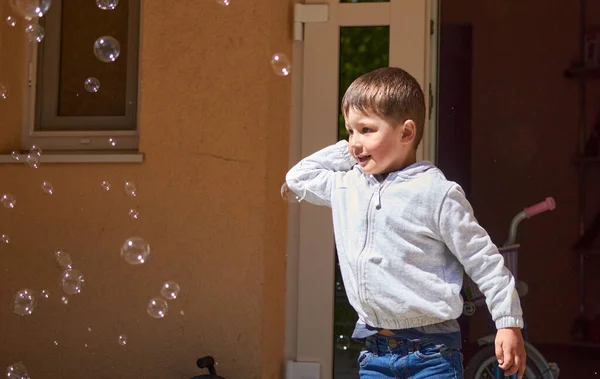 Child having playing and fun with Soap Bubbles at home