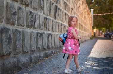  Okuldaki ilk gününde küçük bir kız. Sırt çantalı çocuk şehir caddesinde