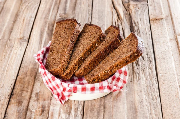 Plátky žitného chleba na dřevěné pozadí — Stock fotografie