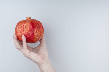 Gri arka planda olgun nar tutarken