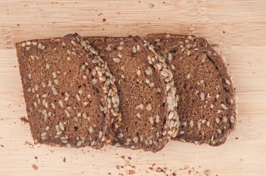 Tahta arka planda tohumlu çavdar ekmeği dilimleri