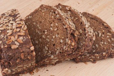 Dilimlenmiş çavdar ekmeği ahşap kesme tahtasına yakın. 