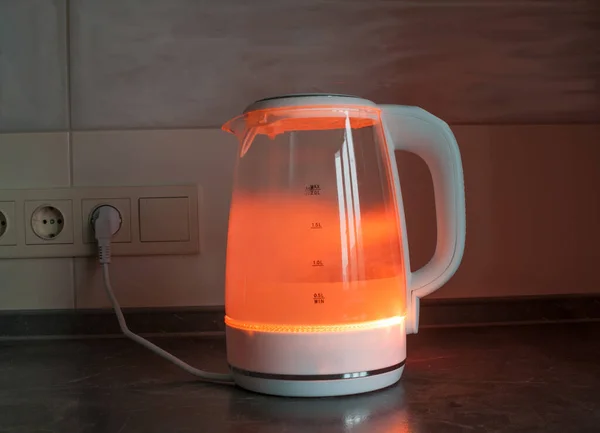 Boiling water in electric kettle with red light
