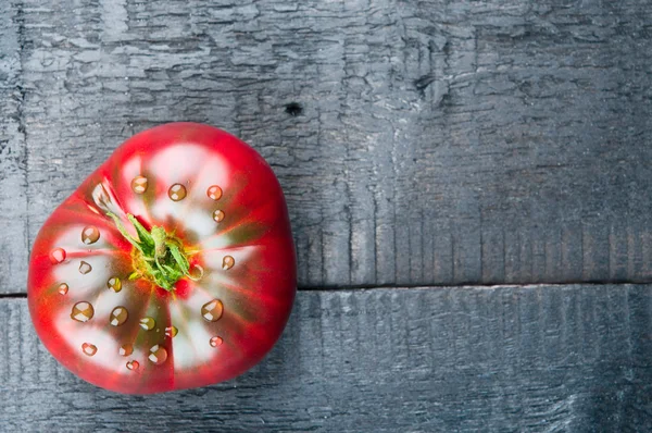 Frische Tomate auf schwarzem Holzhintergrund — Stockfoto