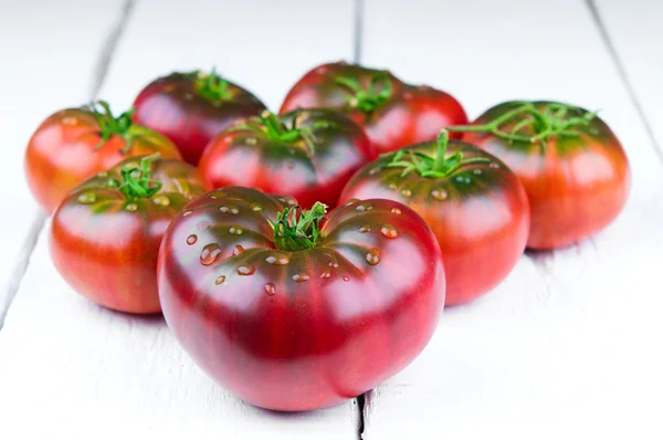 Frische Tomaten auf weißem Holzhintergrund — Stockfoto