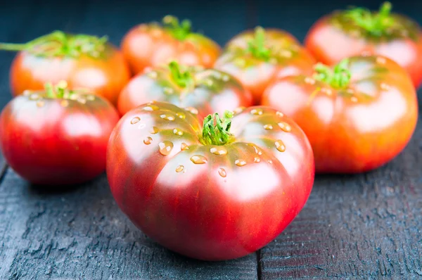 Ripe tomatoes closeup on wooden background — Stock Photo, Image