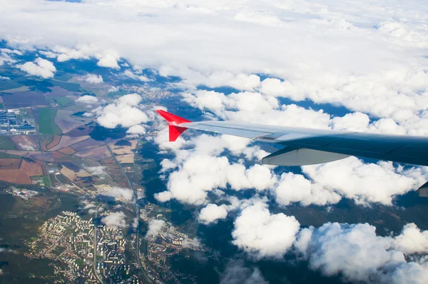 Вид крыла самолета с облаками и землей — стоковое фото