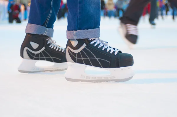 Benen van de man in black ice klapschaatsen — Stockfoto