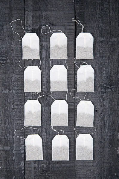 Teabags on black wooden background — Stock Photo, Image