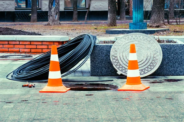 Open manhole with few cables — Stock Photo, Image