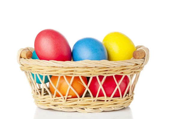 Velikonoční vejce v košíku na bílém pozadí — Stock fotografie