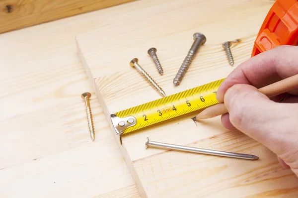 Male hand measuring wood flooring — Stock Photo, Image