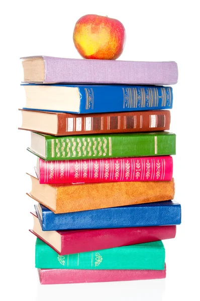 Stapelen van oude boeken en een appel op witte achtergrond — Stockfoto