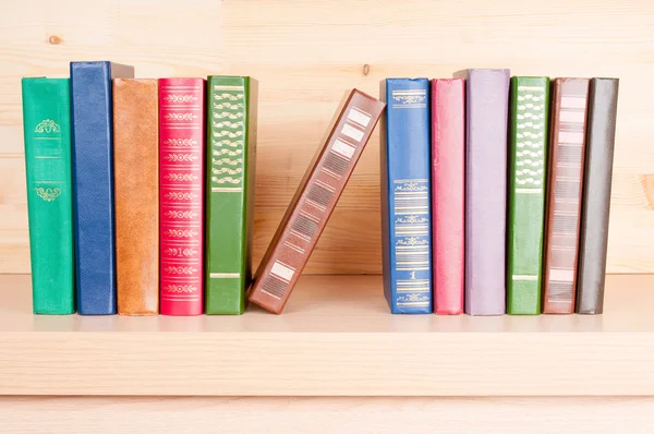 Libros antiguos en un estante de madera — Foto de Stock