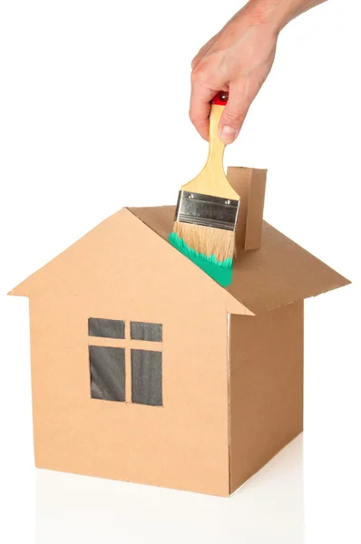Mężczyzna farby model kartonowy domu — Zdjęcie stockowe