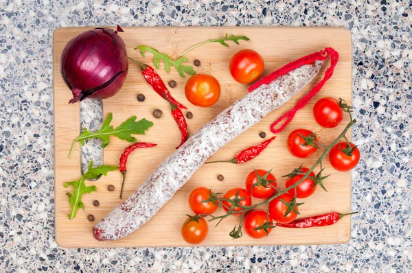 Smoked sausage and vegetables on cutting board — Stock Photo, Image