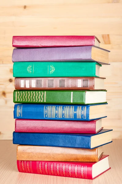 Stack of old books on wooden shelf Stock Photo