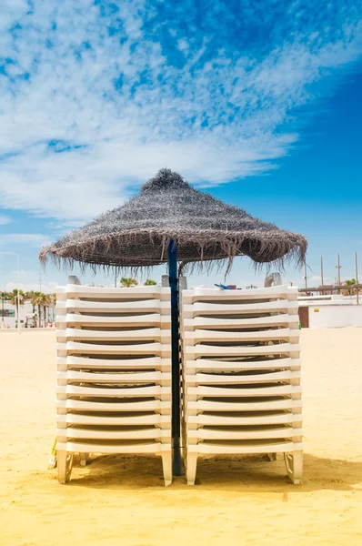 Reed umbrella and sunbeds on the beach — Stock Photo, Image