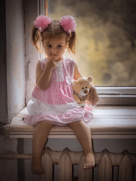 Dívka a medvěd na okenní parapet. — Stock fotografie