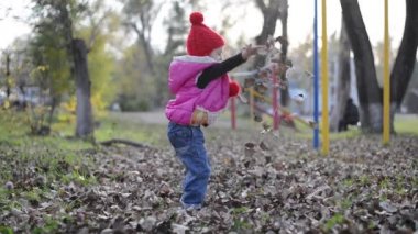 Düşen kuru yapraklar ile oynayan kız...