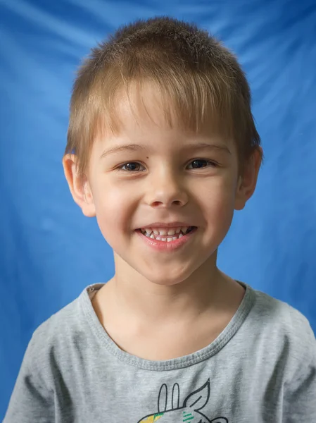 Portret Uroczy Młody Chłopak Uśmiechając Się Zbliżenie Niebieskim Tle — Zdjęcie stockowe