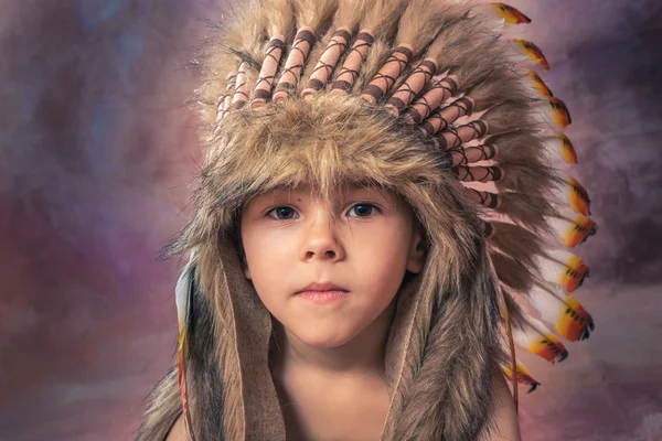 A handsome, cute little boy of 4.5 or 6 years old is dressed in a head-dress as-en-American-Indian — Stock Photo, Image