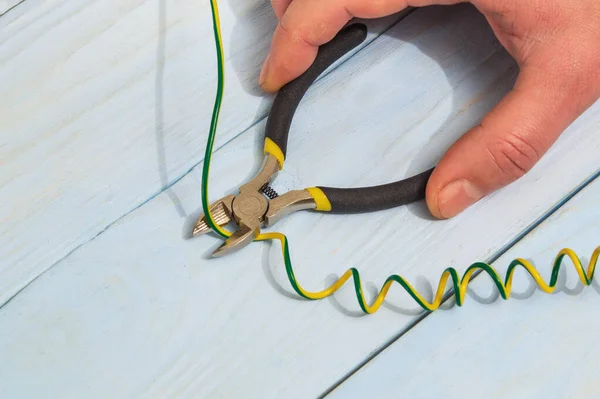 The master electrician cuts the wire with diagonal cutting pliers. Electronics Repair Idea