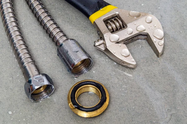 Flexible hoses and adjustable wrenchin water drops during equipment repair during an accident