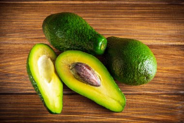 Antika ahşap masadaki avokado. Çiğ meyve sağlıklı yeşil yiyecek. Avokado bayrağı veya diyet konsepti