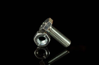 Siyah izole arkaplanda metal cıvata ve ceviz parçaları birleştirmek için kullanılır