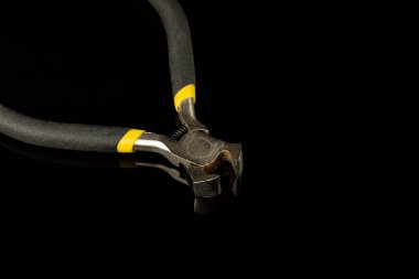 Kara arkaplanda kıskaç var. İnşaatta veya elektrikte kullanılır.