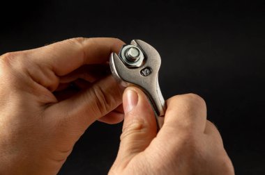 Usta somunu cıvatada bir anahtarla sıkıyor. Yaklaş.