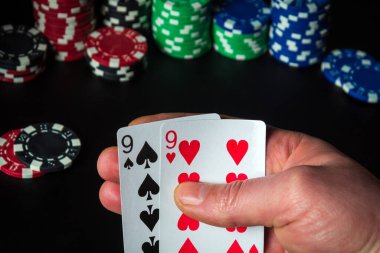 Tek çiftli poker kartları. Kumarbazın eli kumarhanede iskambil oynar.