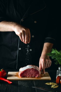 Şef ete tuz serpiyor. Pişirmeden önce et hazırlıyorum. Bir restoranın ya da kafenin mutfağında çalışma ortamı