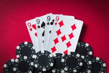 Kazanan poker kombinasyonu aynı türden ya da dörtlü. Poker kulübündeki kırmızı masada fişler ve kartlar