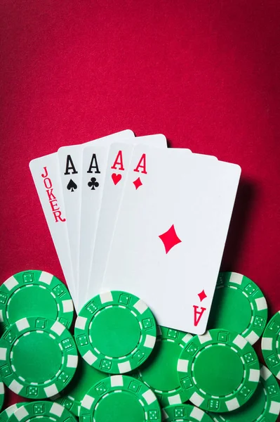 Poker game with five of a kind combination. Chips and cards on the red table. Vertical image
