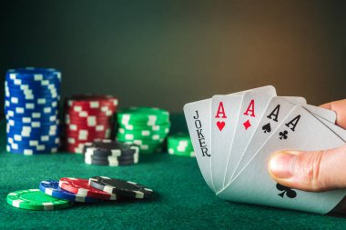 Poker kartları ve beş farklı kombinasyon. Bu maksimum kazanç. Kumarbazın eli poker kulübünde kağıt oynar.