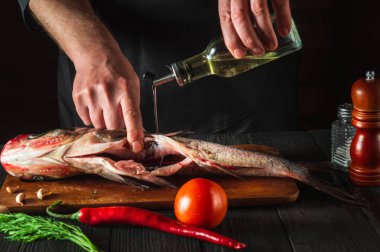 Şef taze balık kocakafalı sazan balığı hazırlıyor. Balık yemi pişirmeye hazırlanıyorum. Restoranda ya da kafe mutfağında çalışma ortamı