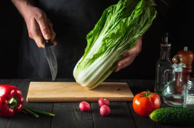 Profesyonel bir şef taze lahana salatası yapar. Restoranın mutfağında dilimleme hazırlığı. Sebze diyeti fikri.