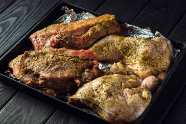 Fırında pişirmek için çiğ et ve tavuk bacağı hazır. Ulusal et yemeği bayram arifesinde hazırlanır..